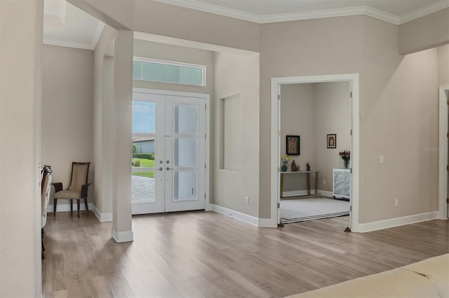 entrance foyer with french doors, wood finished floors, ornamental molding, and baseboards