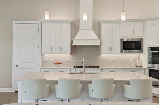 kitchen with built in microwave, premium range hood, decorative backsplash, light countertops, and double oven