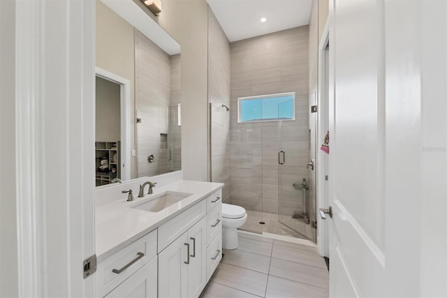 full bath featuring a stall shower, vanity, tile patterned floors, and toilet