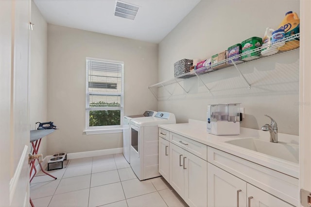 laundry room with washer and dryer, cabinet space, light tile patterned flooring, and baseboards