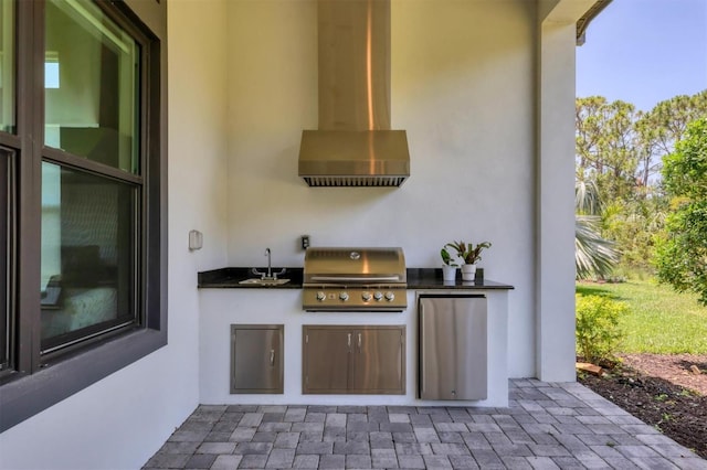 view of patio with grilling area, a sink, and exterior kitchen