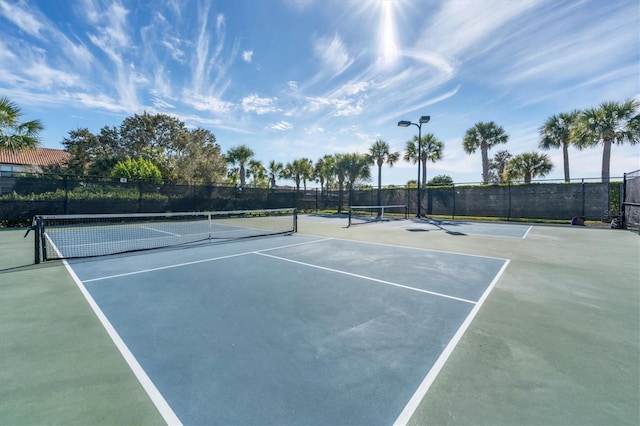view of tennis court featuring fence