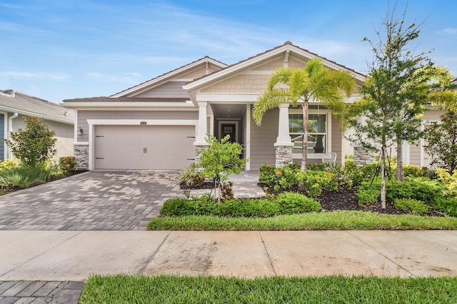 5770 Long Shore Loop, Sarasota, FL 34238 - craftsman-style home featuring an attached garage, decorative driveway, covered porch, and stone siding