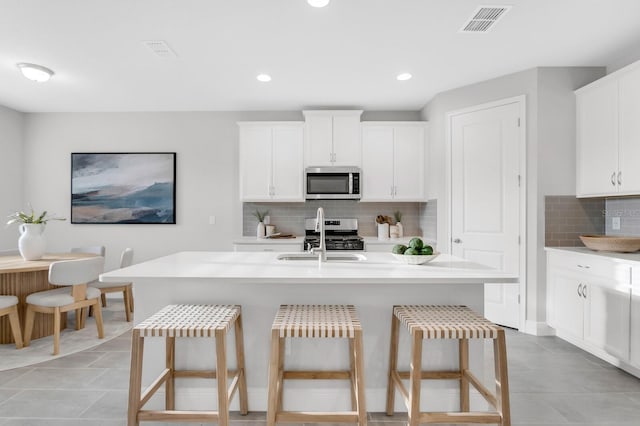 5770 Long Shore Loop, Sarasota, FL 34238 - kitchen featuring appliances with stainless steel finishes, a kitchen breakfast bar, backsplash, light countertops, and recessed lighting