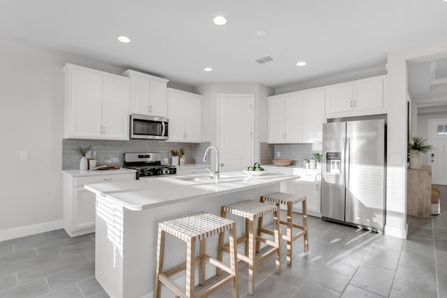 5770 Long Shore Loop, Sarasota, FL 34238 - kitchen with stainless steel appliances, backsplash, light countertops, recessed lighting, and a kitchen bar