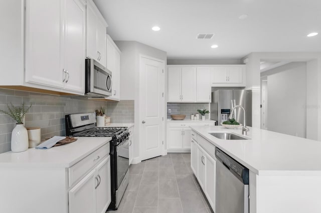 5770 Long Shore Loop, Sarasota, FL 34238 - kitchen with stainless steel appliances, light countertops, white cabinets, decorative backsplash, and light tile patterned flooring