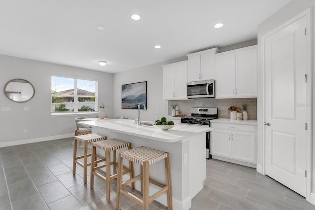 5770 Long Shore Loop, Sarasota, FL 34238 - kitchen with appliances with stainless steel finishes, a kitchen bar, backsplash, a kitchen island with sink, and light countertops