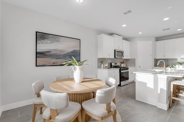 5770 Long Shore Loop, Sarasota, FL 34238 - kitchen featuring gas range, stainless steel microwave, decorative backsplash, light countertops, and recessed lighting
