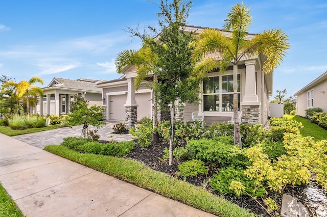 5770 Long Shore Loop, Sarasota, FL 34238 - obstructed view of property with an attached garage, stone siding, driveway, and stucco siding