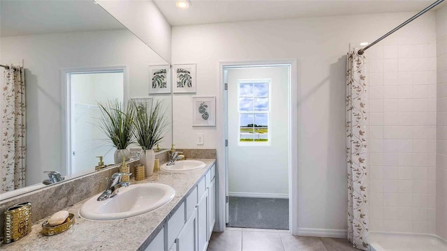 full bath featuring a stall shower, tile patterned floors, double vanity, and baseboards