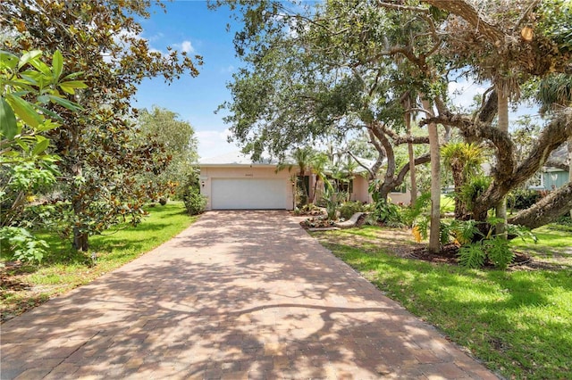 4443 Robin Hood Trl W, Sarasota, FL 34232 - view of front of house featuring driveway, a front yard, a garage, and stucco siding