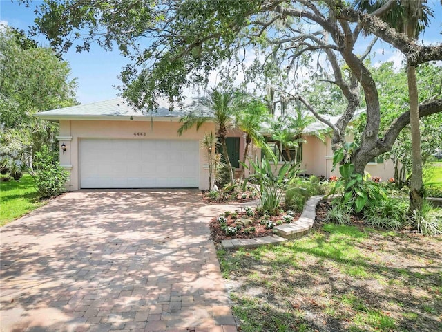 4443 Robin Hood Trl W, Sarasota, FL 34232 - view of front facade featuring decorative driveway, stucco siding, and an attached garage