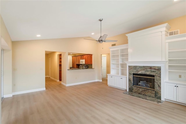 4443 Robin Hood Trl W, Sarasota, FL 34232 - unfurnished living room featuring a high end fireplace, light wood finished floors, lofted ceiling, ceiling fan, and baseboards