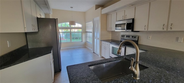 7102 52nd Dr E, Bradenton, FL 34203 - kitchen with stainless steel appliances, a sink, light tile patterned floors, pendant lighting, and dark stone countertops