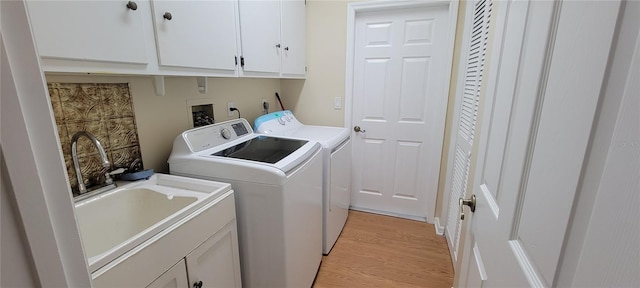 7102 52nd Dr E, Bradenton, FL 34203 - washroom featuring washing machine and dryer, cabinet space, and light wood-type flooring