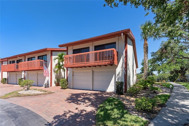 709 Sorrento Inlt Unit 709, Nokomis, FL 34275 - view of front of property featuring a balcony, stucco siding, decorative driveway, and a tiled roof