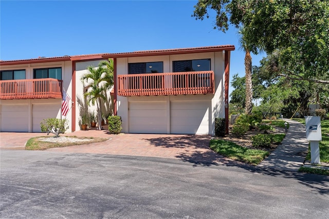 709 Sorrento Inlt Unit 709, Nokomis, FL 34275 - mediterranean / spanish house featuring a balcony, an attached garage, stucco siding, and decorative driveway