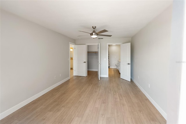 709 Sorrento Inlt Unit 709, Nokomis, FL 34275 - unfurnished bedroom featuring light wood-style flooring, a walk in closet, baseboards, a closet, and ceiling fan