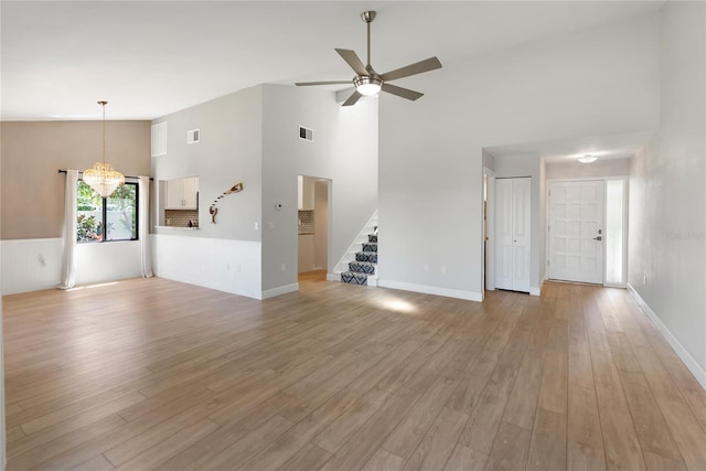 709 Sorrento Inlt Unit 709, Nokomis, FL 34275 - unfurnished living room with high vaulted ceiling, stairs, a ceiling fan, light wood-style flooring, and baseboards