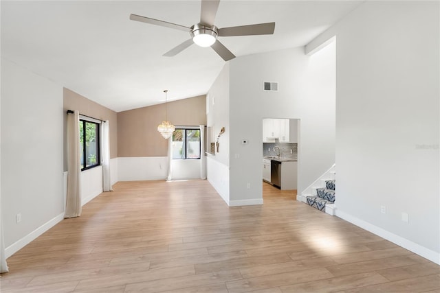 709 Sorrento Inlt Unit 709, Nokomis, FL 34275 - unfurnished living room featuring vaulted ceiling, a chandelier, light wood-style floors, a ceiling fan, and stairs