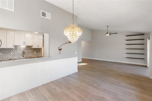 709 Sorrento Inlt Unit 709, Nokomis, FL 34275 - unfurnished living room featuring ceiling fan, a chandelier, light wood-style flooring, a sink, and high vaulted ceiling