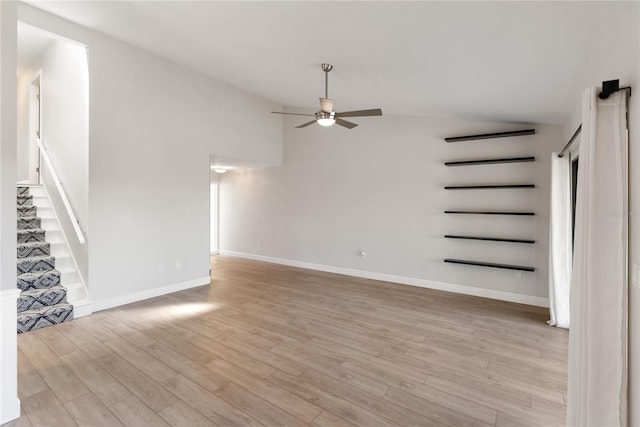 709 Sorrento Inlt Unit 709, Nokomis, FL 34275 - unfurnished living room featuring a ceiling fan, lofted ceiling, light wood-style flooring, stairs, and baseboards