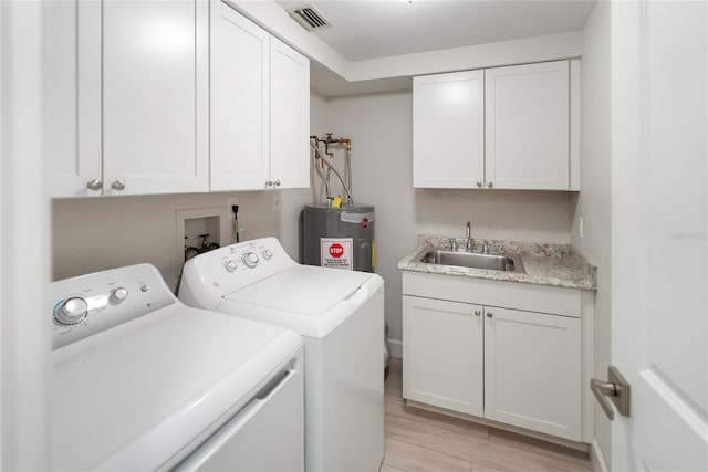 709 Sorrento Inlt Unit 709, Nokomis, FL 34275 - laundry area featuring electric water heater, washer and dryer, cabinet space, bar with sink, and light wood finished floors