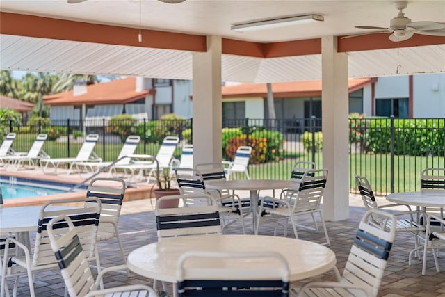 709 Sorrento Inlt Unit 709, Nokomis, FL 34275 - view of patio with a ceiling fan, fence, a community pool, and outdoor dining space