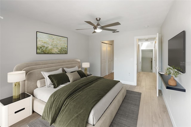 709 Sorrento Inlt Unit 709, Nokomis, FL 34275 - bedroom featuring a closet, baseboards, light wood-type flooring, and a ceiling fan