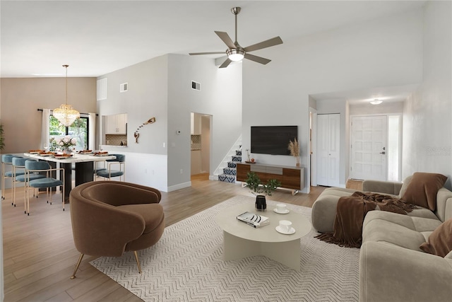 709 Sorrento Inlt Unit 709, Nokomis, FL 34275 - living area featuring high vaulted ceiling, light wood-style floors, stairway, a ceiling fan, and baseboards