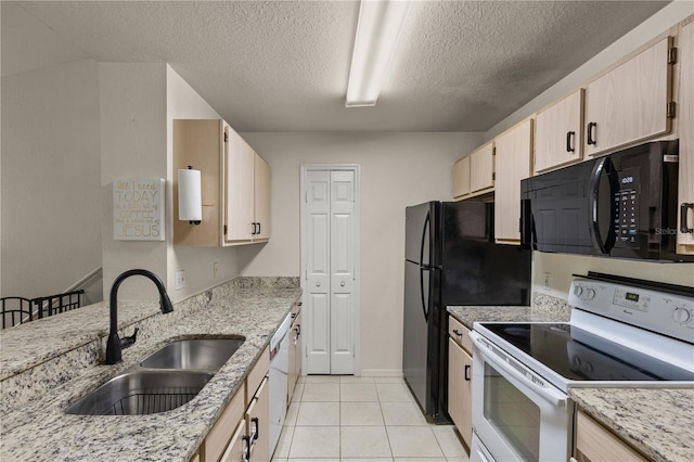 8926 Manor Loop Unit 201, Lakewood Ranch, FL 34202 - kitchen with black appliances, a sink, a textured ceiling, light brown cabinets, and light stone countertops
