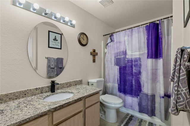 8926 Manor Loop Unit 201, Lakewood Ranch, FL 34202 - full bath featuring a textured wall, vanity, toilet, a textured ceiling, and tile patterned flooring