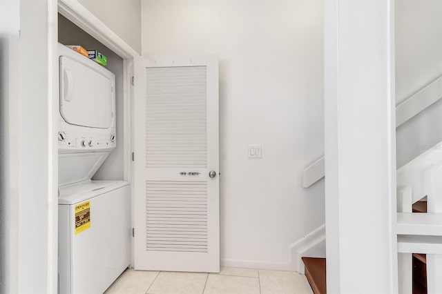603 Cedars Ct, Longboat Key, FL 34228 - washroom with stacked washing machine and dryer, light tile patterned flooring, and baseboards