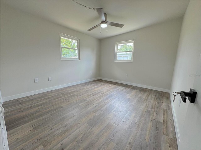 1902 24th Ave W, Bradenton, FL 34205 - spare room with plenty of natural light, ceiling fan, wood finished floors, and baseboards