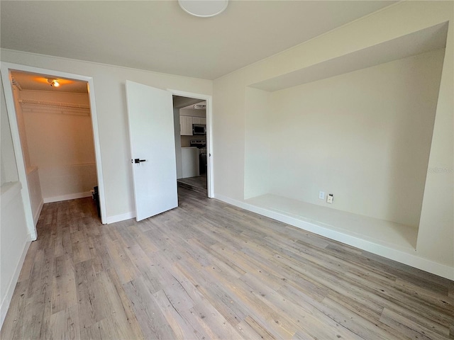 1902 24th Ave W, Bradenton, FL 34205 - unfurnished bedroom with a spacious closet, a closet, light wood-type flooring, and baseboards