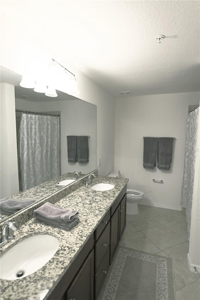 16904 Vardon Ter Unit 208, Lakewood Ranch, FL 34211 - bathroom featuring double vanity, tile patterned floors, toilet, a textured ceiling, and baseboards
