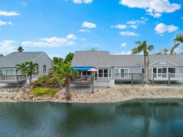 rear view of property featuring a deck with water view