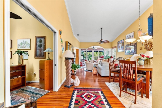 foyer entrance featuring crown molding, wood finished floors, a ceiling fan, vaulted ceiling, and baseboards