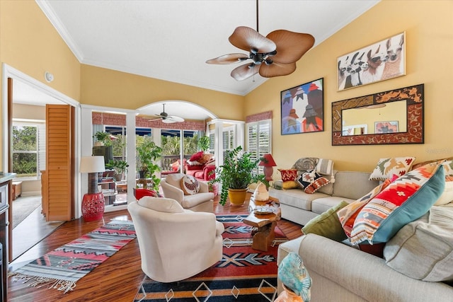 living room with a ceiling fan, wood finished floors, ornamental molding, and lofted ceiling