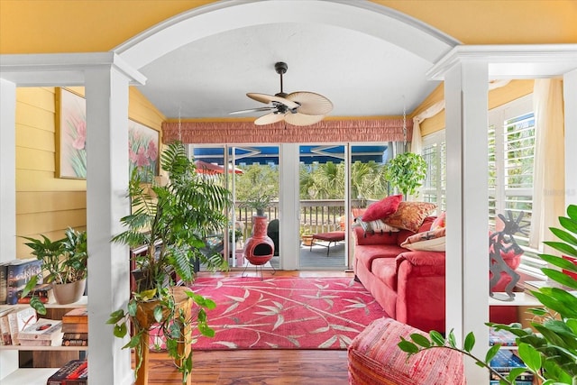 sunroom / solarium featuring arched walkways, wood finished floors, and wooden walls