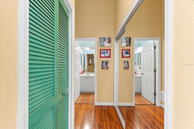 hallway with wood finished floors and a sink