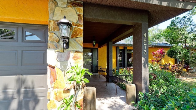 4873 Huntleigh Dr, Sarasota, FL 34233 - doorway to property with stone siding and covered porch