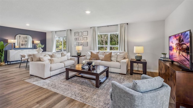 living room with wood finished floors, recessed lighting, and baseboards