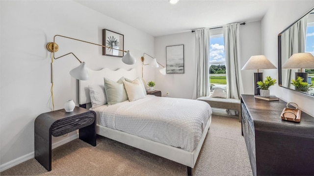 bedroom featuring light colored carpet and baseboards