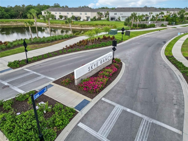 9064 Driven Snow St, Sarasota, FL 34241 - view of asphalt road with traffic signs, a water view, curbs, a residential view, and sidewalks