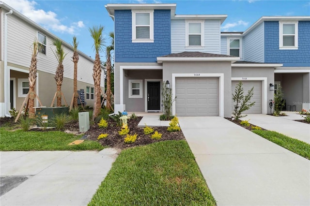 9064 Driven Snow St, Sarasota, FL 34241 - view of front facade featuring stucco siding, concrete driveway, an attached garage, and central AC