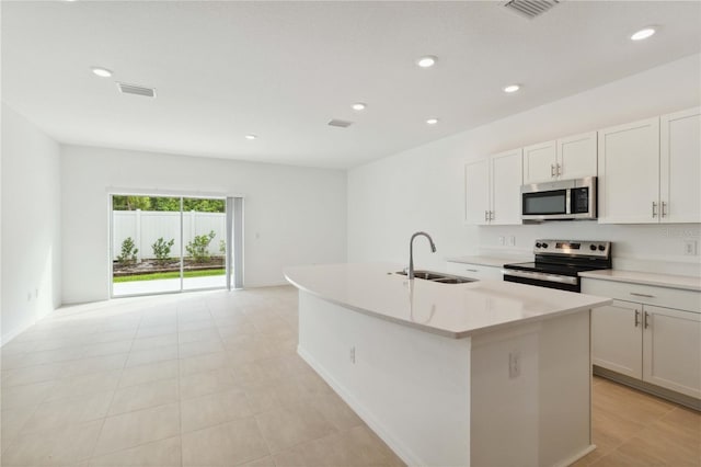 9064 Driven Snow St, Sarasota, FL 34241 - kitchen featuring appliances with stainless steel finishes, a sink, a center island with sink, recessed lighting, and light countertops
