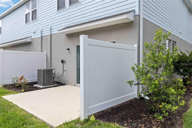 9064 Driven Snow St, Sarasota, FL 34241 - view of property exterior with central air condition unit, a patio, and stucco siding