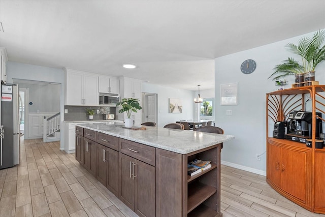 4708 26th Ave W, Bradenton, FL 34209 - kitchen with appliances with stainless steel finishes, wood tiled floors, open shelves, white cabinetry, and a center island