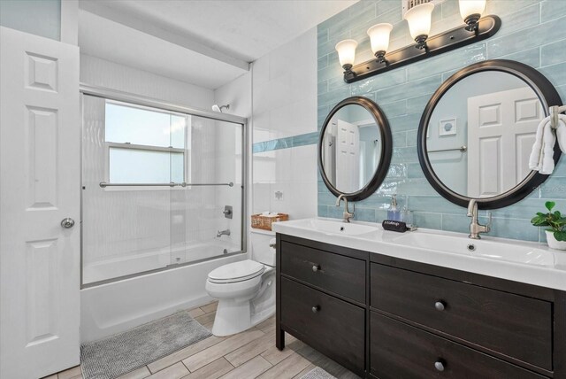 4708 26th Ave W, Bradenton, FL 34209 - bathroom featuring backsplash, tile walls, bath / shower combo with glass door, double vanity, and toilet